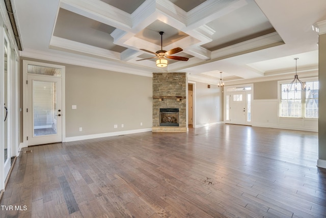 unfurnished living room with ceiling fan with notable chandelier, a fireplace, wood finished floors, and crown molding