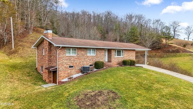 ranch-style home with brick siding, a front yard, central AC unit, a chimney, and driveway