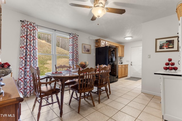 dining space with light tile patterned floors, a ceiling fan, and baseboards