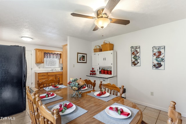 dining room featuring light tile patterned floors, ceiling fan, a textured ceiling, and baseboards