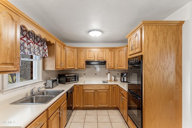 kitchen featuring under cabinet range hood, black appliances, light countertops, and a sink