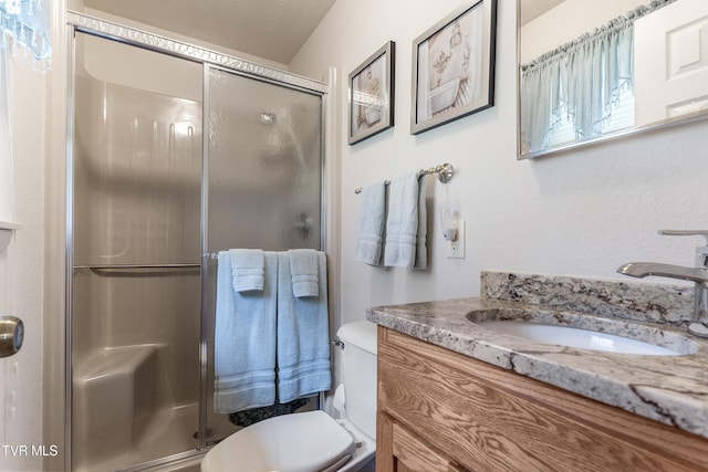 bathroom featuring a stall shower, toilet, and vanity