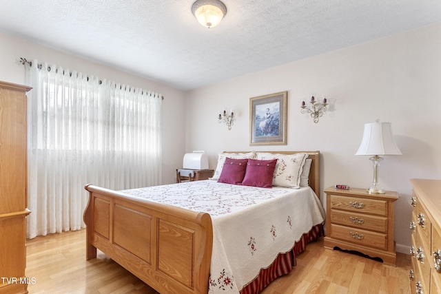 bedroom featuring a textured ceiling and light wood finished floors