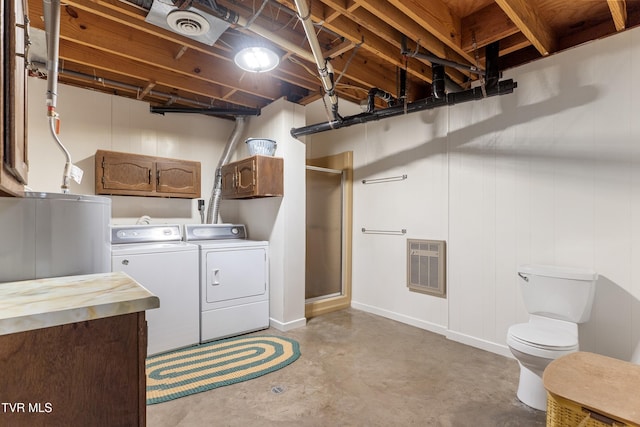 laundry area featuring visible vents, heating unit, cabinet space, and washer and clothes dryer