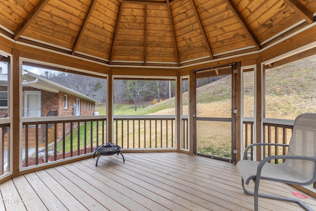 unfurnished sunroom featuring wood ceiling and vaulted ceiling with beams