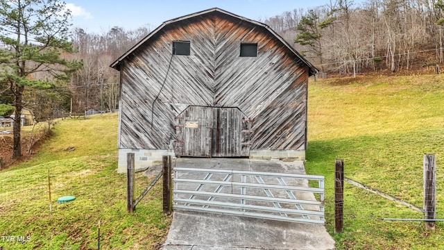 view of front facade featuring an outbuilding, a front lawn, and fence