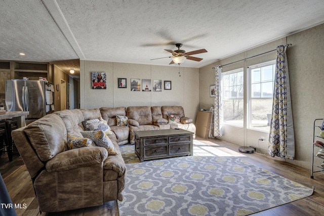 living room featuring a textured ceiling, a ceiling fan, and wood finished floors