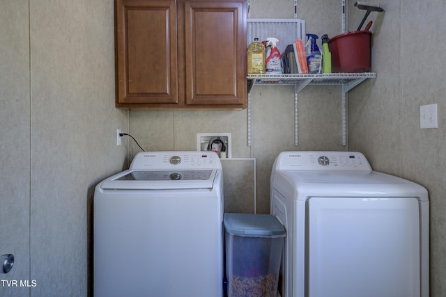 clothes washing area with independent washer and dryer and cabinet space