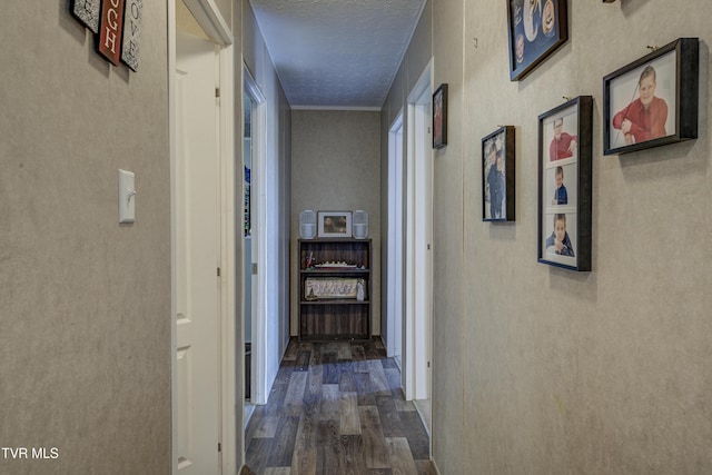 corridor featuring a textured ceiling and dark wood-style flooring