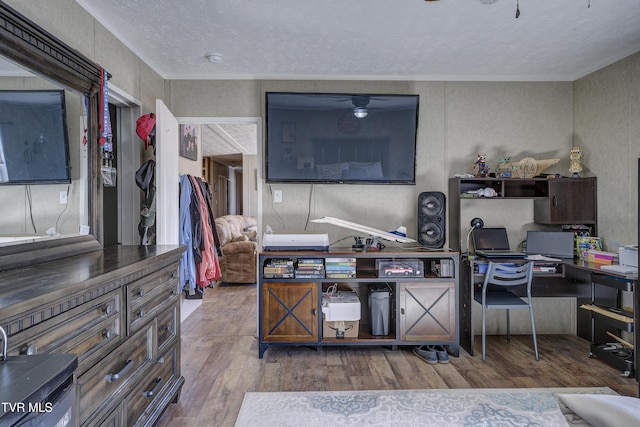 home office with ceiling fan, a textured ceiling, and wood finished floors