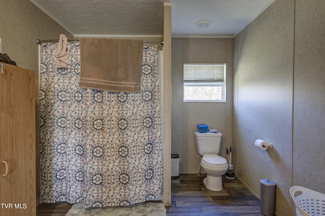 full bathroom with toilet, a shower with curtain, a textured ceiling, and wood finished floors