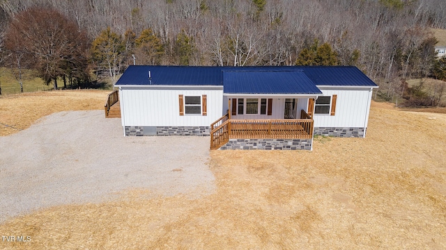 view of front of house featuring crawl space, covered porch, driveway, and metal roof