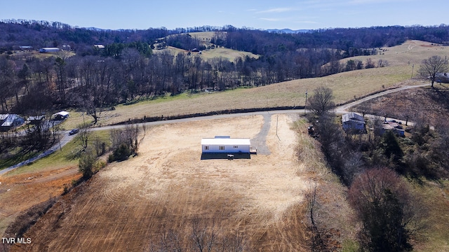 aerial view featuring a rural view and a wooded view