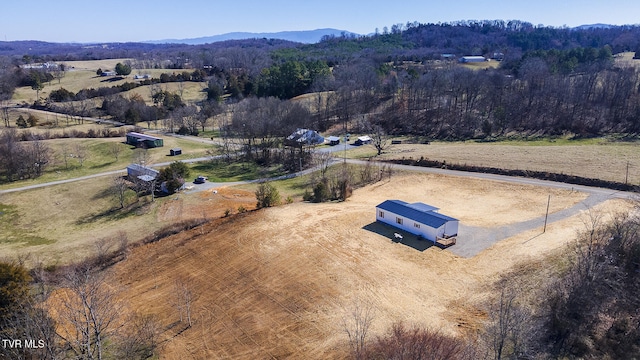 drone / aerial view featuring a rural view, a mountain view, and a view of trees