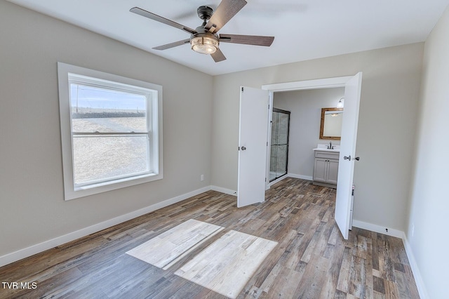 unfurnished bedroom featuring a ceiling fan, baseboards, connected bathroom, and light wood finished floors