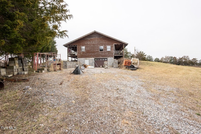 back of house featuring driveway and an attached garage