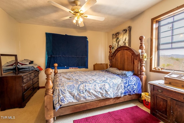 carpeted bedroom featuring a textured ceiling and a ceiling fan