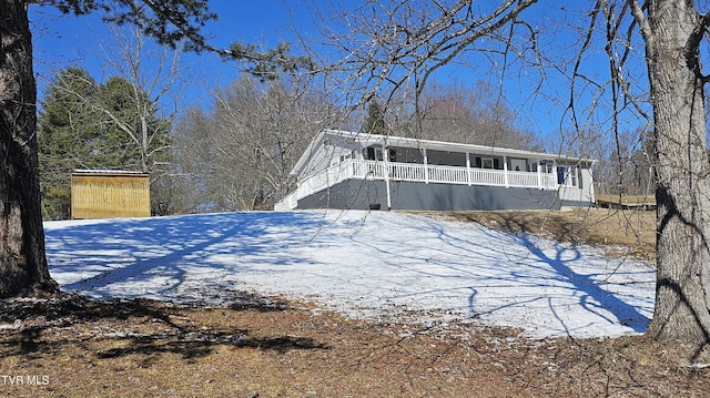 snow covered property featuring a porch