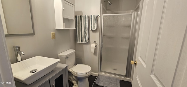 bathroom featuring a stall shower, vanity, and toilet