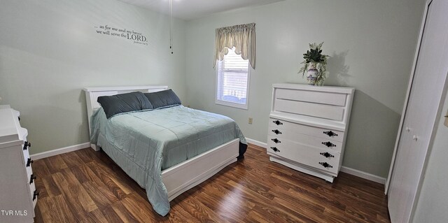 bedroom featuring dark wood-style flooring and baseboards