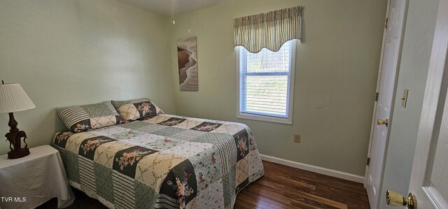 bedroom featuring baseboards and wood finished floors