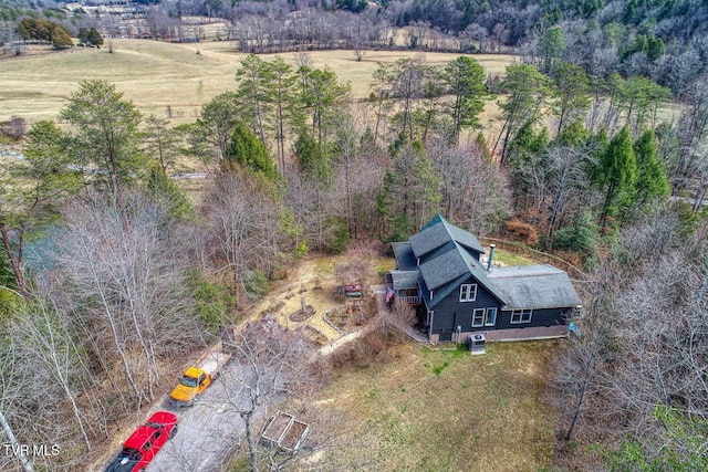 birds eye view of property featuring a rural view and a wooded view