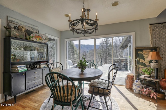 dining room with a chandelier, visible vents, and light wood-style flooring