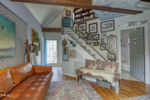 living area with stairway, beamed ceiling, wood finished floors, and visible vents