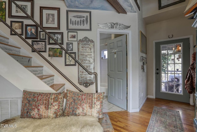 entrance foyer featuring stairs, wood finished floors, visible vents, and baseboards