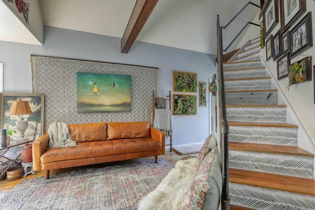 staircase with wood finished floors and beam ceiling