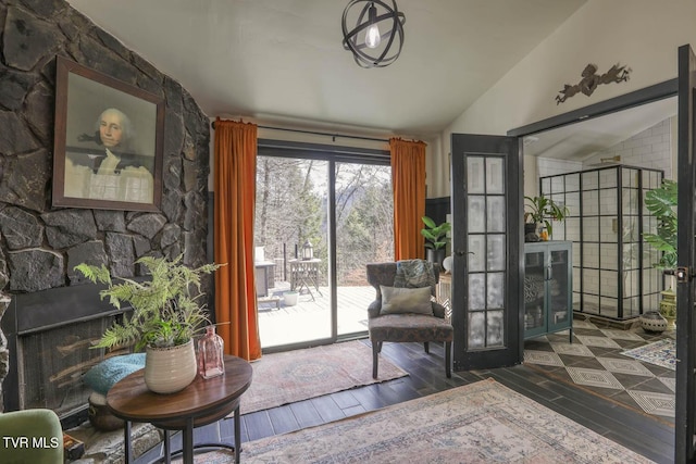 sitting room featuring lofted ceiling, a fireplace, and dark wood-type flooring