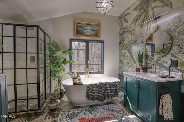 bathroom featuring lofted ceiling, a freestanding tub, vanity, a shower stall, and tile patterned floors