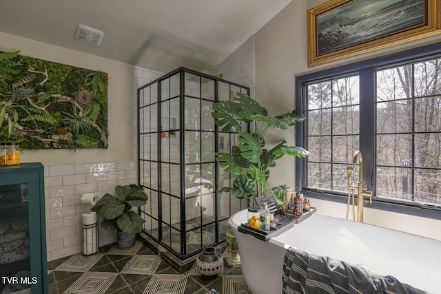 interior space featuring a wealth of natural light, visible vents, tile walls, and a shower stall