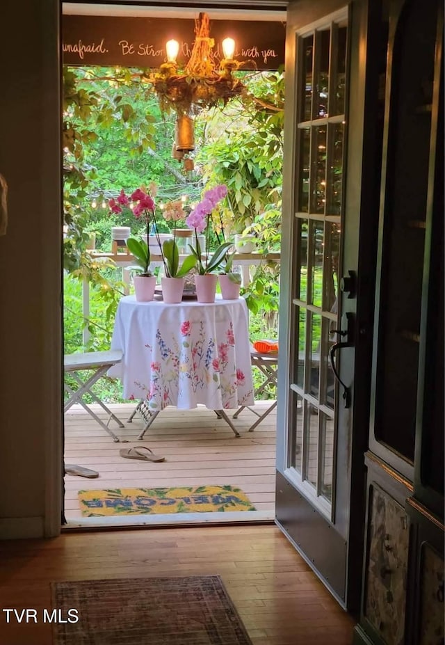 doorway featuring an inviting chandelier and wood finished floors