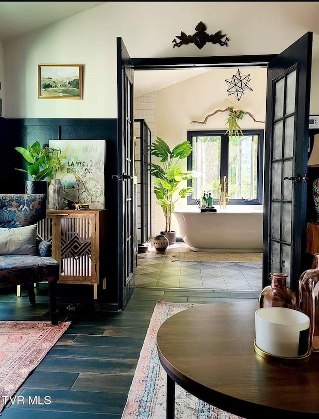 interior space with lofted ceiling, french doors, and wood finished floors