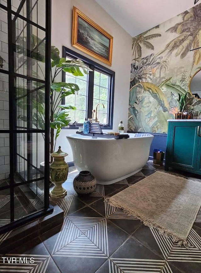 bathroom with a freestanding bath and tile patterned floors