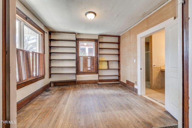 spare room with baseboards and hardwood / wood-style floors