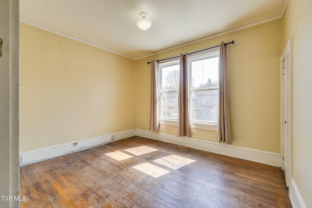 unfurnished room featuring hardwood / wood-style floors, baseboards, and ornamental molding