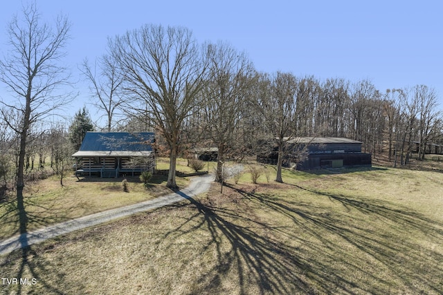 view of front of home featuring a barn, a front lawn, metal roof, and an outdoor structure