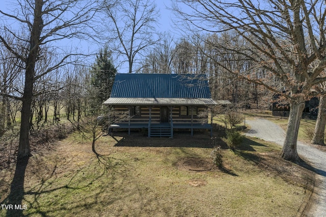 exterior space featuring metal roof, driveway, and a porch