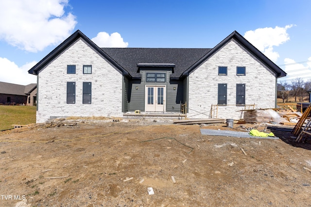 view of front facade featuring french doors and stone siding