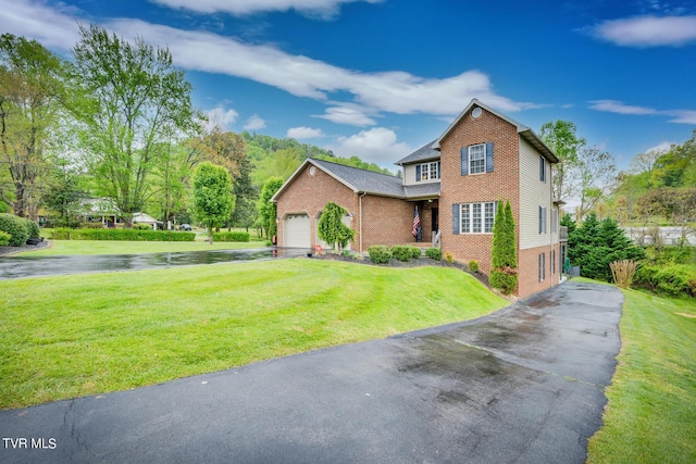 view of front of home with an attached garage, a front yard, aphalt driveway, and brick siding