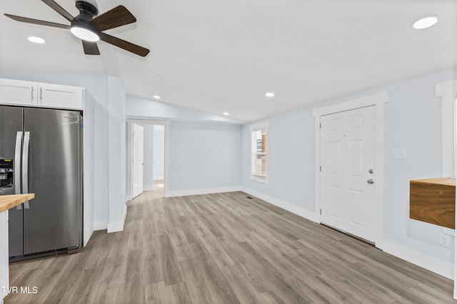 unfurnished living room with lofted ceiling, light wood-style flooring, baseboards, and recessed lighting