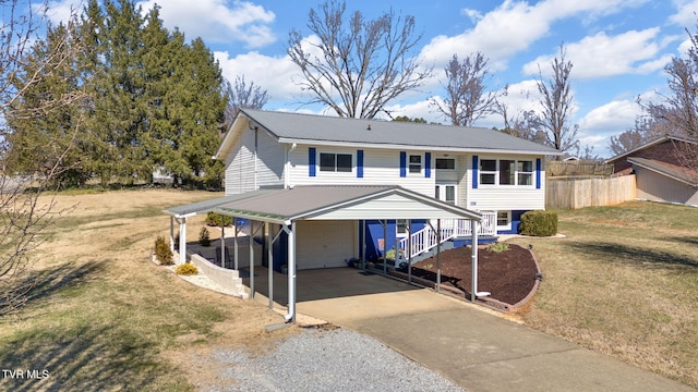 view of front of house featuring metal roof, gravel driveway, fence, a front lawn, and a carport