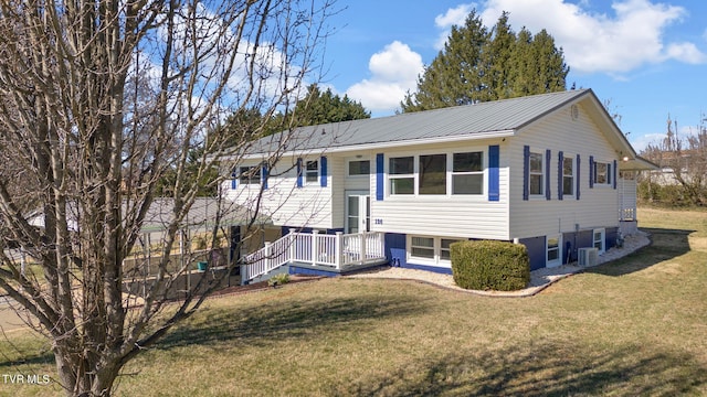 split foyer home featuring metal roof, a front lawn, and central air condition unit