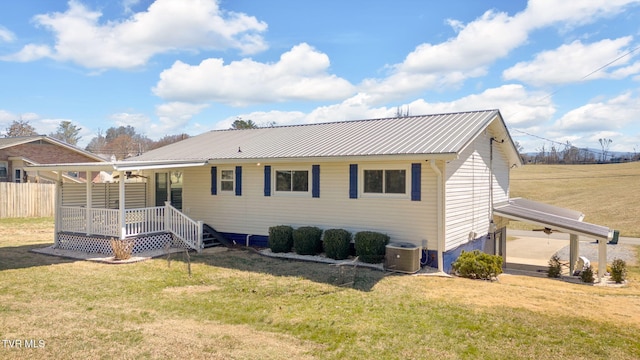 back of property featuring metal roof, a yard, and a porch