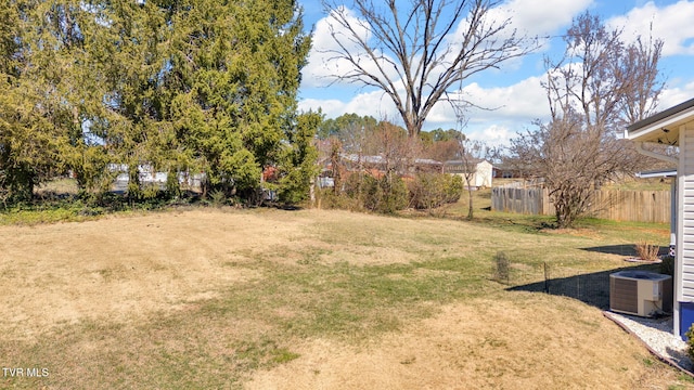 view of yard with fence and central air condition unit