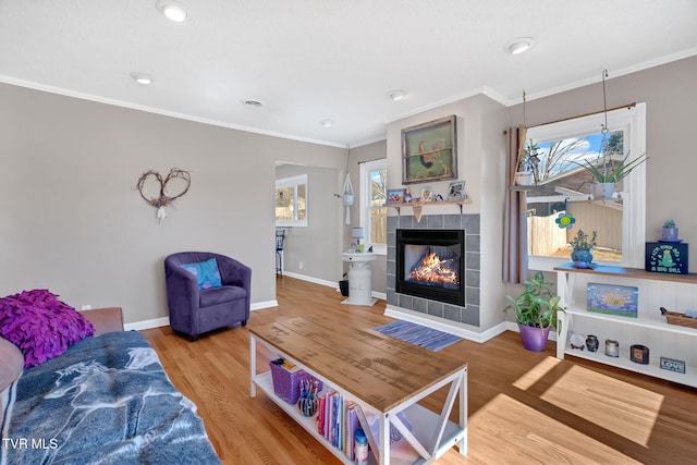 living area featuring ornamental molding, wood finished floors, and a healthy amount of sunlight