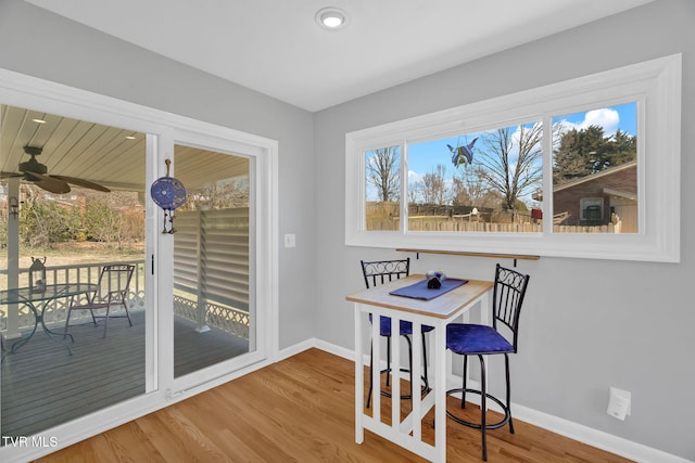 dining space with baseboards and wood finished floors