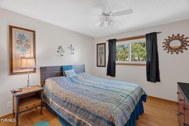 bedroom featuring a textured ceiling, ceiling fan, light wood-type flooring, and baseboards